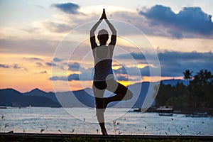 Caucasian woman practicing yoga at seashore