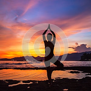 Caucasian woman practicing yoga at seashore