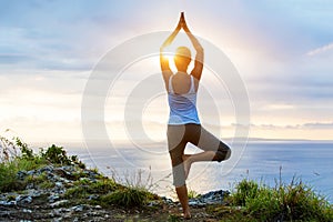 Caucasian woman practicing yoga at seashore