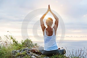 Caucasian woman practicing yoga at seashore