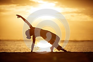 Caucasian woman practicing yoga at seashore