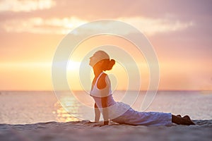 Caucasian woman practicing yoga at seashore