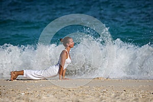 Caucasian woman practicing yoga at seashore