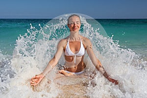 Caucasian woman practicing yoga at seashore