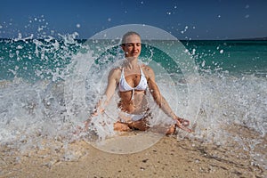 Caucasian woman practicing yoga at seashore