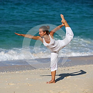 Caucasian woman practicing yoga at seashore