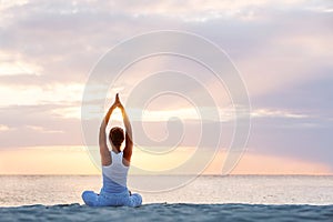 Caucasian woman practicing yoga at seashore photo