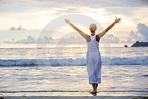 Caucasian woman practicing yoga at seashore of tropic ocean