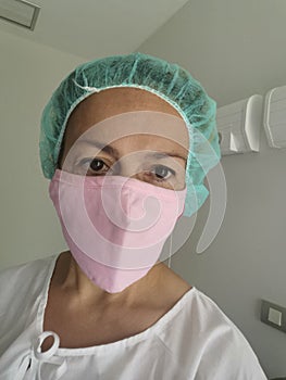 Caucasian woman ready for blepharoplasty or eyelid beauty - Female surgeon or hospital patient with pink mask in a room hospital