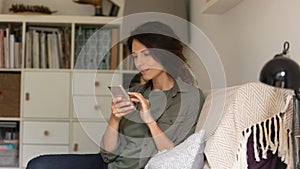 Caucasian woman relax on couch using cellphone