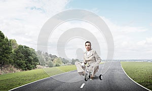 Caucasian woman riding kid& x27;s bicycle on road