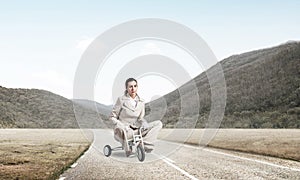 Caucasian woman riding kid& x27;s bicycle on road