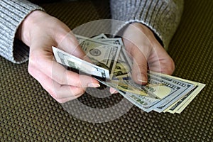 Caucasian woman`s hands counting dollar banknotes. Female holding money currency of United States