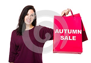 Caucasian woman show with shopping bag and showing autumn sale