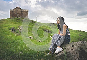 Caucasian Woman sits on the rock