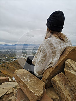 Caucasian woman sitting on a rocky sofa enjoying the view from Living Room Trailhead hike