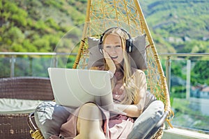 Caucasian woman sitting on the terrace working from home using computer laptop. Young woman teaches a foreign language