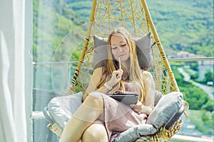 Caucasian woman sitting on the terrace working from home using computer laptop. Young woman teaches a foreign language