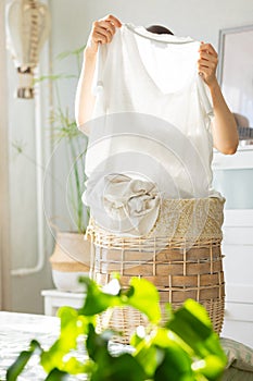 caucasian woman sorting dirty laundry basket, laundry at home