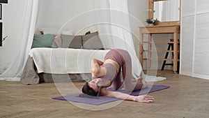 caucasian woman in sportswear performs yoga asanas Sukshma Vyayama, Sivananda