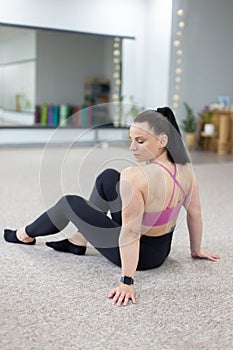 Caucasian woman in sportswear resting and looking on her shoulder vertical