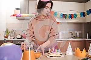 Caucasian woman standing at the kitchen and preparing to the birthday party of her child