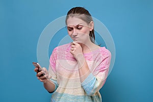 Caucasian woman staring at her mobile phone in disbelief