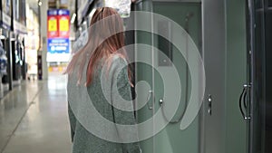 Caucasian woman in store chooses a shower stall for the bathroom