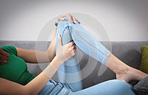 Caucasian woman suffering from knee pain at home