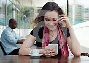 Caucasian woman surfing the internet and drinking coffee in a cafeteria