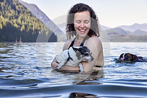 Caucasian Woman swimming in a lake with dog