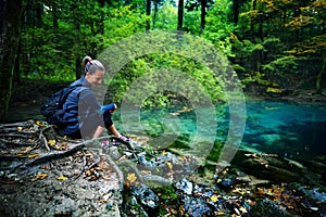 caucasian woman tourist relaxing by the river, in the forest, Ochiul Beiului, Romania