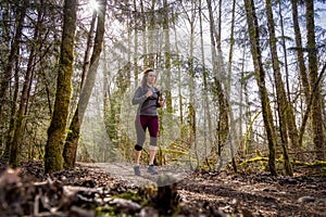 Caucasian Woman Trail Running in the Green Forest