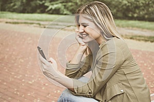 Caucasian woman using smart phone outdoor.