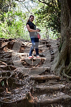 Caucasian woman walks on stairsteps from the roots of the trees in Japanese garden in Kamakura city, Japan