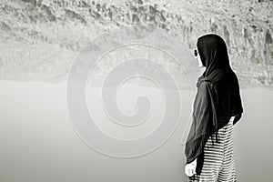 Caucasian woman watch Maharlu pink salt lake reflections mountains panorama in Shiraz, Iran