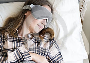 Caucasian woman wearing eye mask sleeping in bed