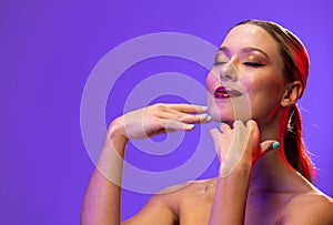 Caucasian woman wearing red lipstick and blue nail polish on blue background, copy space