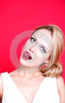 Caucasian woman wearing white dress on red background licking her lips
