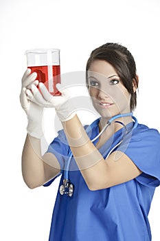 Caucasian woman working as a laboratory technician studing a beaker
