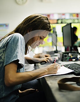 Caucasian woman writing at computer room