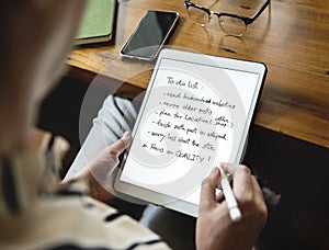 Caucasian woman writing to do list on tablet