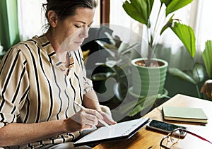 Caucasian woman writing to do list on tablet