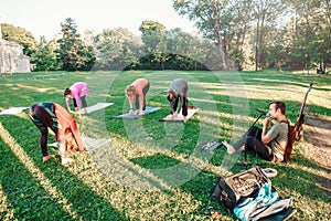 Caucasian women doing yoga in park outside on sunset