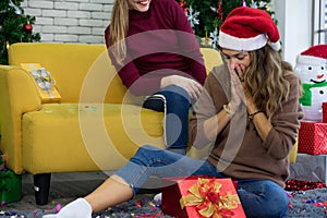 Caucasian women friends wearing Santa hat in Christmas festival party and gift box.