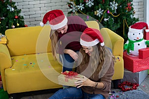 Caucasian women friends wearing Santa hat in Christmas festival party and gift box.