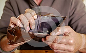 Caucasian worker  with a missing finger showing hes empty wallet