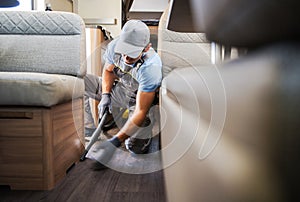 Worker Vacuuming and Cleaning Rental RV Motor Home photo