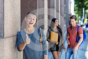 Caucasian young adult man in city with group of students