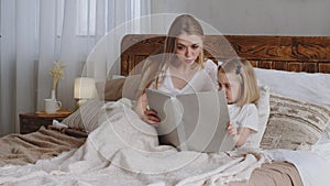 Caucasian young adult single mother woman mom reading fairy tale book to beloved little daughter girl child toddler kid